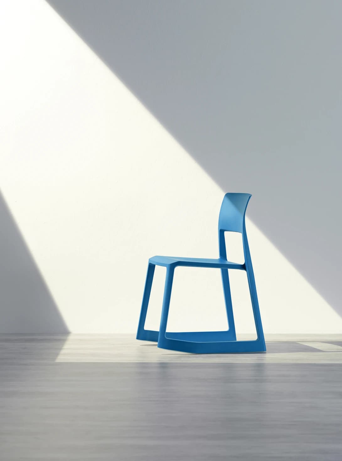 A modern armless chair with a sleek, minimalist design, rendered in a solid blue color. It features a single-piece construction for the seat, backrest, and frame, suggesting molded plastic or a similar material. The backrest is gently curved, and the legs are integrated into the seat's structure. — 3D model