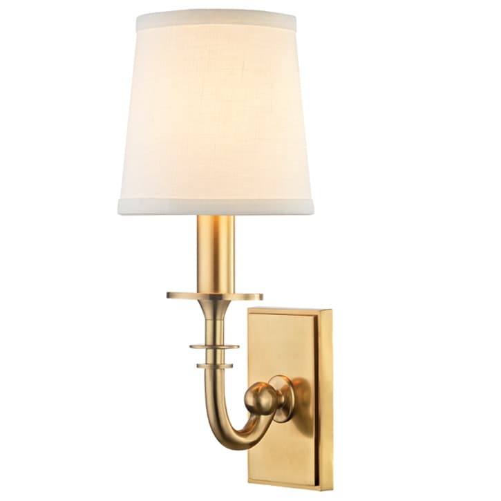 A single-arm wall sconce featuring a rectangular brass backplate, a gracefully curved brass arm, and a candle-style stem topped with a tapered off-white fabric shade. The brass finish appears brushed or polished, conveying a classic aesthetic. The design is clean and elegant, suitable for various interior styles. — 3D model
