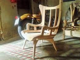 A light-toned wooden armchair featuring a high, slightly curved backrest with vertical slats and int… — 3D model