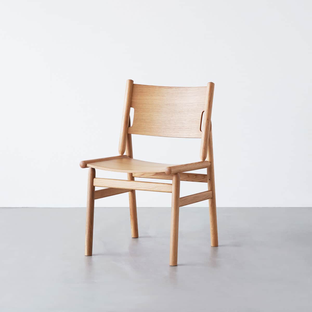 A minimalist wooden chair with a curved backrest and a contoured seat. The chair features a simple c… — free STL 3D model