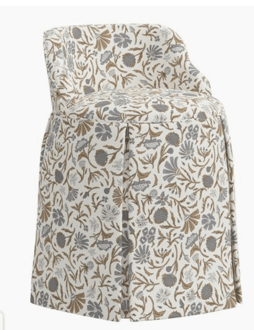 An upholstered accent chair with a skirted base and a rounded back. The chair is covered in a fabric with a dense floral pattern in shades of grey, tan, and off-white. The skirt features pleating detail. — 3D model