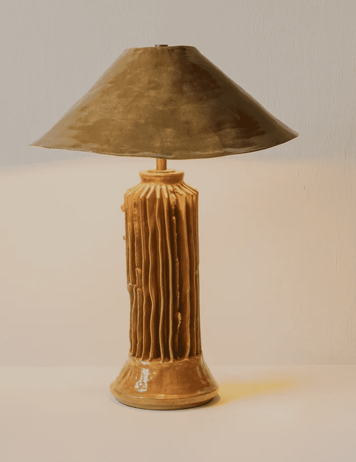 A distinctive table lamp featuring an organically textured ceramic base with vertical ridges and a w… — 3D model