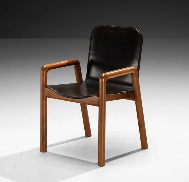 A modern armchair with a dark, possibly leather, seat and backrest, supported by a visible wooden frame. The armrests are integrated into the wooden structure and have a curved, rounded profile. The legs are straight and also made of wood. The overall design appears to be minimalist and functional. — 3D model