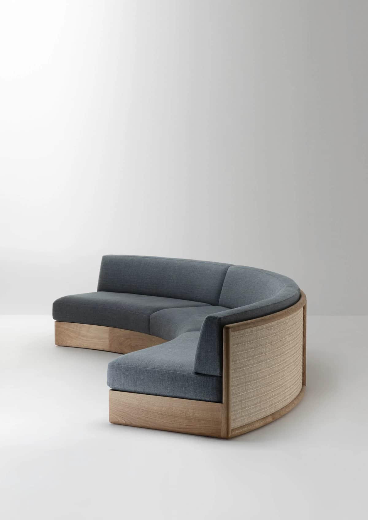 A large, curved sectional sofa featuring gray upholstered seats and backrests, set on a light wood b… — free SKP 3D model