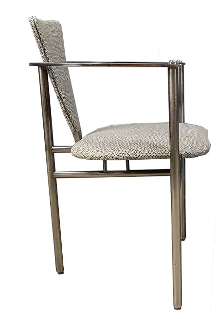 A modern armchair with a tubular metal frame and upholstered seat and backrest. The frame is constructed from polished chrome or stainless steel, featuring cylindrical legs and armrests. The seat and backrest are upholstered in a light-colored fabric with a speckled pattern. The design is minimalist and functional. — 3D model