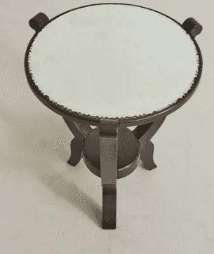A circular end table with a light-colored, textured top and a dark wooden base. The base features a… — 3D model