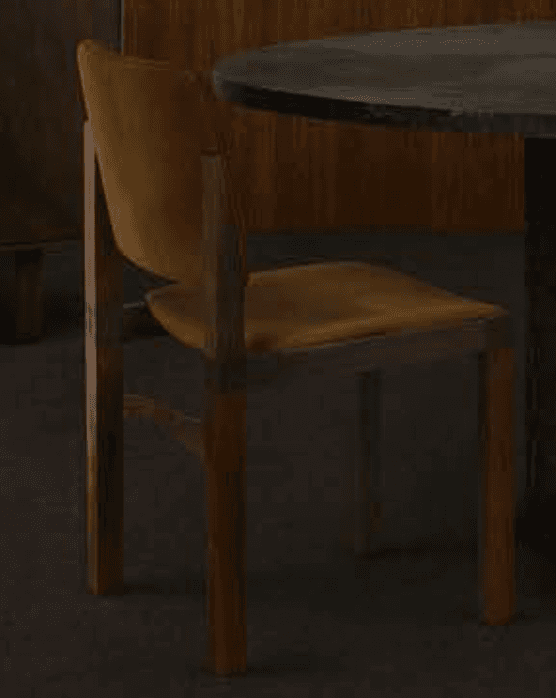A modern dining chair featuring a minimalist design with a solid wood frame and upholstered seat and backrest. The frame has straight, angular legs and an integrated support structure for the seat and back. The upholstery is a mustard yellow fabric, complementing the warm tones of the natural wood. — 3D model
