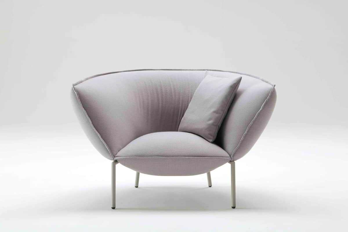 A light grey upholstered lounge armchair featuring a deep, rounded seat and backrest with prominent… — 3D model