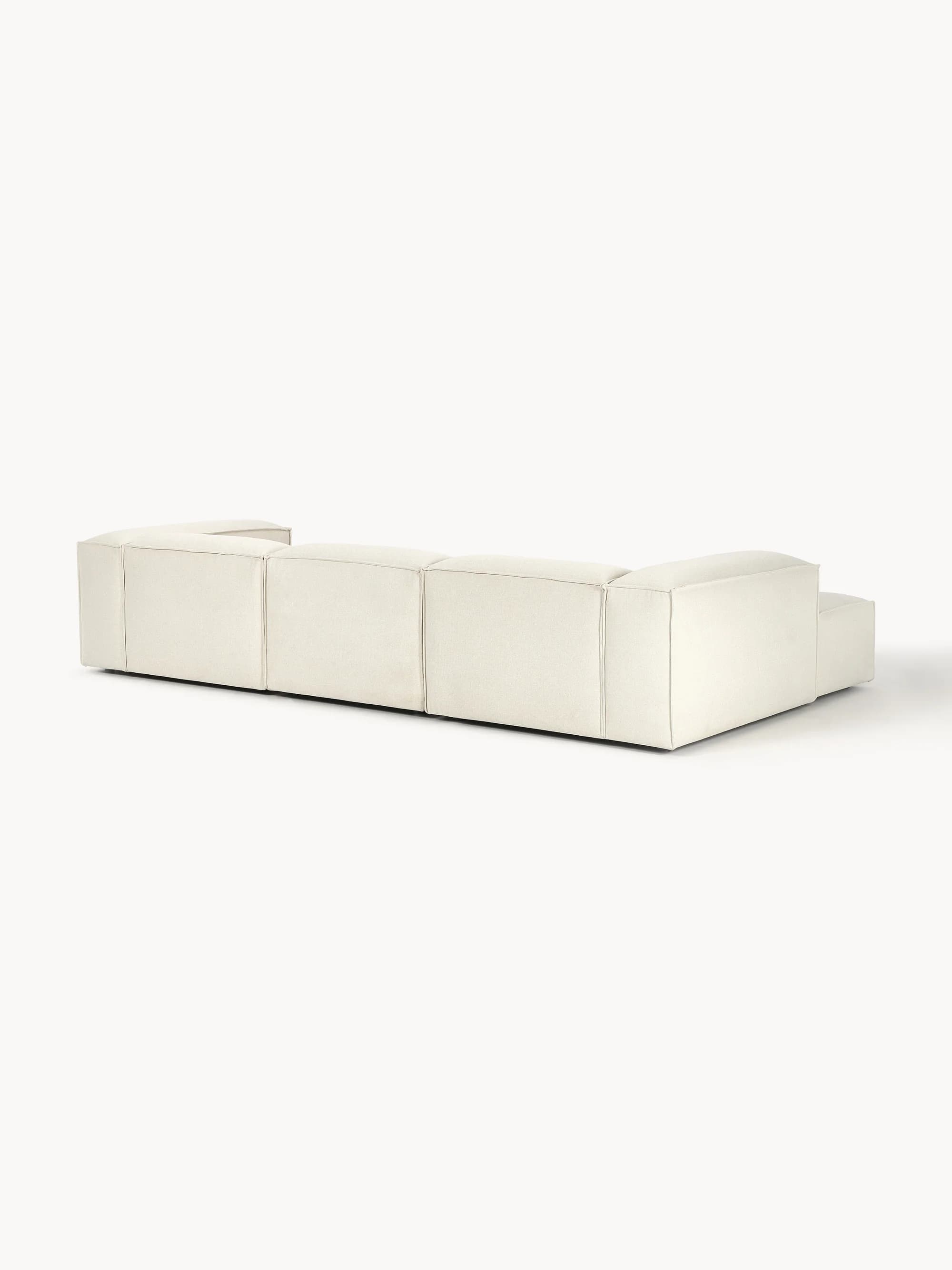 A modular sofa with clean lines and a low profile. It appears to be upholstered in a textured fabric and consists of multiple sections, suggesting flexibility in configuration. The sofa has a contemporary design with a boxy silhouette and visible stitching that delineates the segments. — 3D model
