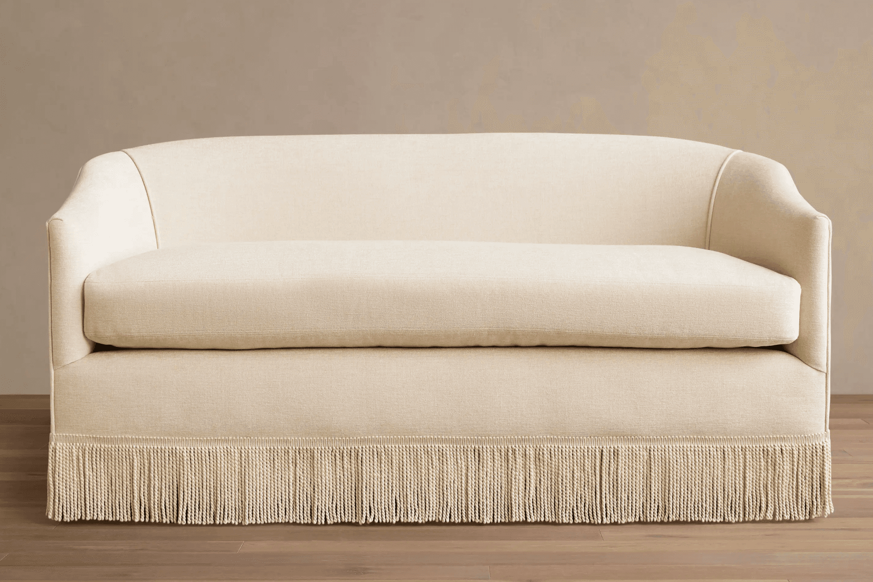 A light-colored, upholstered loveseat featuring a rounded back and integrated arms, with a distinctive fringed skirt along its base. — 3D model