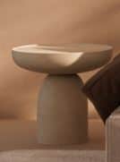 A contemporary side table featuring a monolithic, sculptural design. It has a round top with a sligh… — 3D model