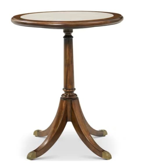 A classic-style pedestal accent table featuring a round, dark-stained wooden top with a central light-colored, possibly marble or stone, inlay. The table stands on a turned central column that transitions into a quadrapod base of splayed, curved legs, each terminating in a decorative brass paw foot. — 3D model