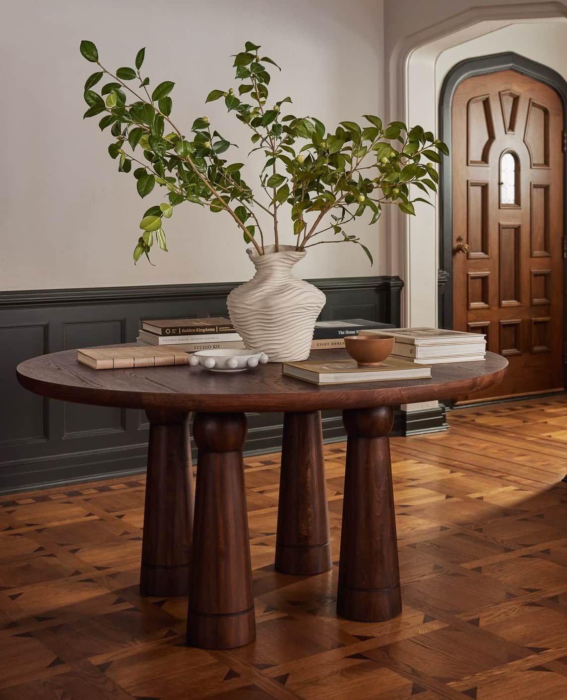 A round coffee table made from dark brown wood, featuring a thick circular top supported by three ro… — free GLB 3D model