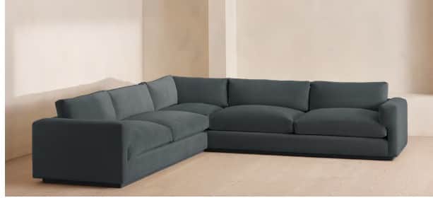 An L-shaped sectional sofa upholstered in a dark blue or slate-colored fabric. The sofa features a l… — 3D model