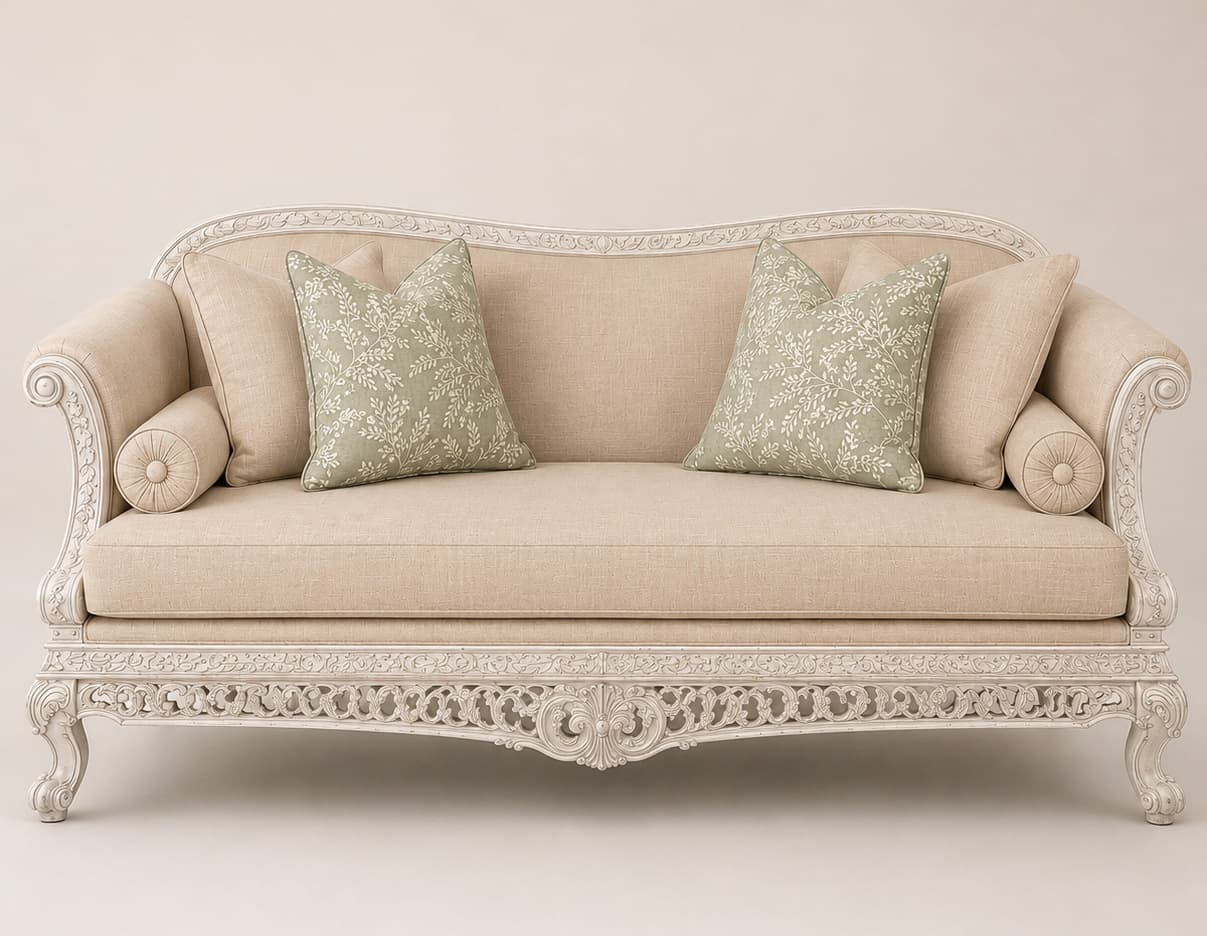 An elegantly carved daybed in a Rococo or French Provincial style, featuring a light beige upholstered seat and backrest, and an elaborately detailed antique white finished wooden frame. It includes multiple decorative pillows, some plain beige and others with a sage green botanical pattern. — 3D model