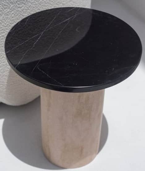A contemporary round pedestal table featuring a polished black marble top with white veining, suppor… — 3D model