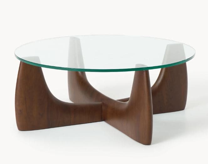 A coffee table featuring a circular clear glass top supported by a distinctive sculptural wooden base made of three interlocking curved elements. — 3D model
