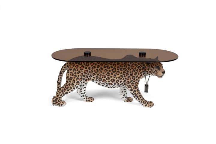 An oval coffee table supported by a realistically rendered leopard sculpture. The tabletop is made o… — 3D model