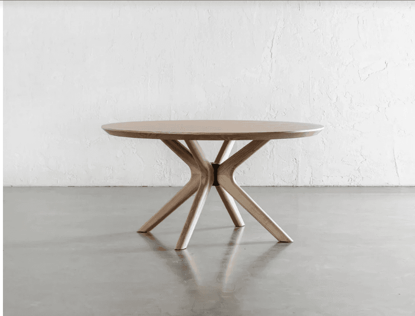 A modern round side table featuring a light-toned wooden tabletop and a sculptural base composed of… — 3D model