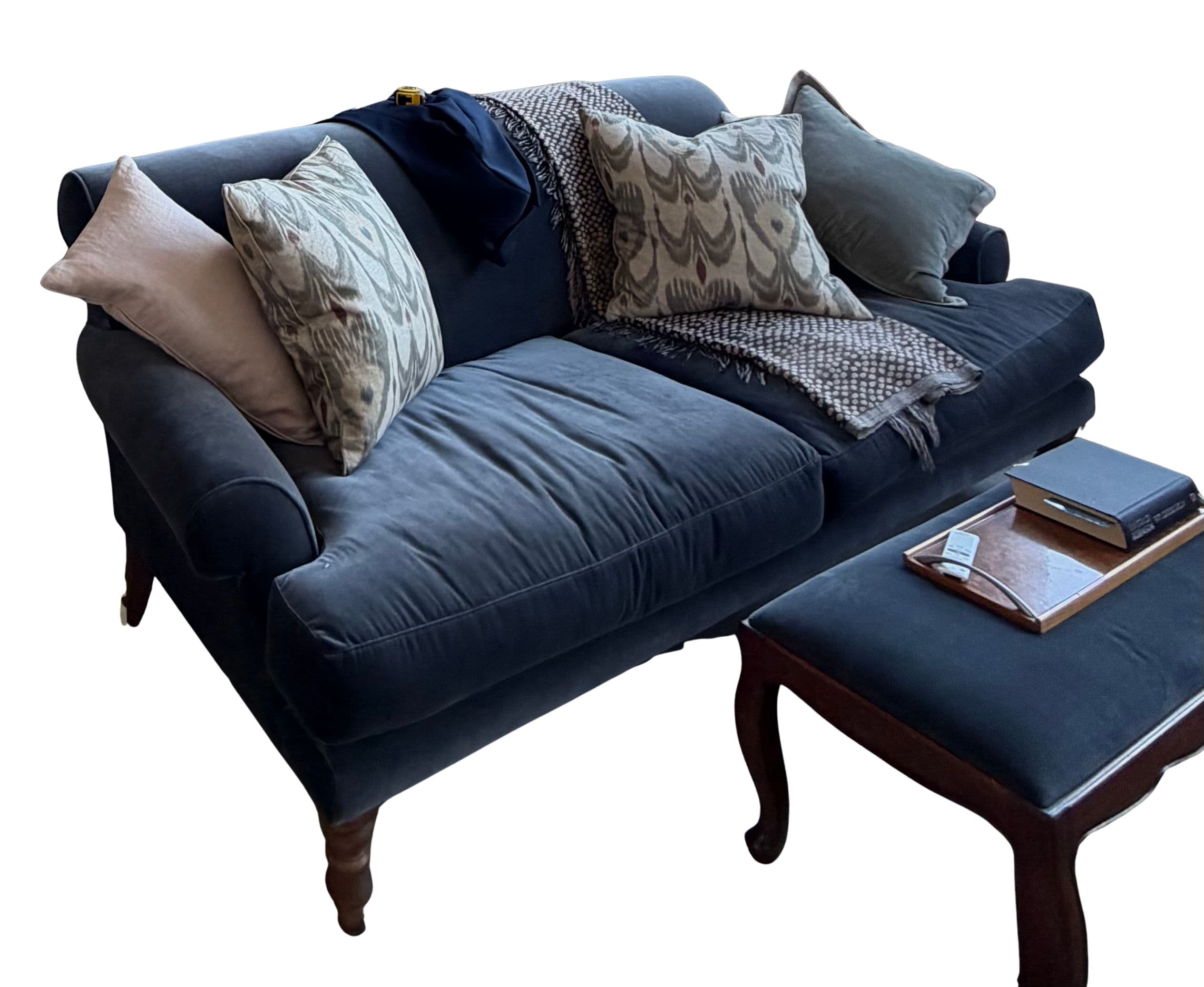A two-seat sofa featuring a plush dark blue velvet upholstery, rolled armrests, and a skirted base with visible turned wooden legs. It is adorned with several throw pillows and a knitted blanket, suggesting a cozy and inviting aesthetic. — 3D model