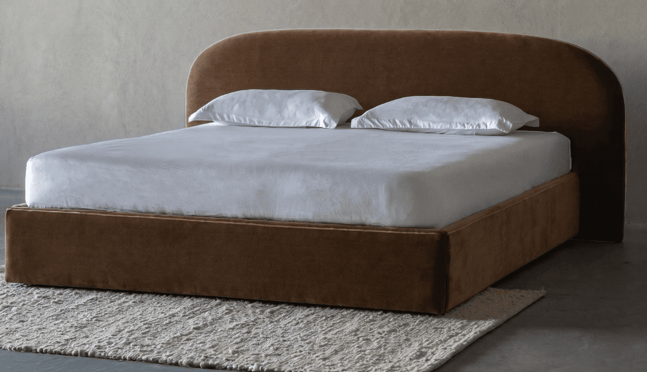 A modern platform bed featuring a continuous upholstered frame and a distinctive curved headboard, presented on a white background with white bedding. — 3D model