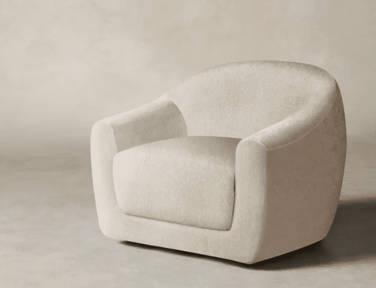 A contemporary, fully upholstered lounge chair in a light, textured boucle fabric, featuring a rounded, sculptural form and a low-profile design. — 3D model