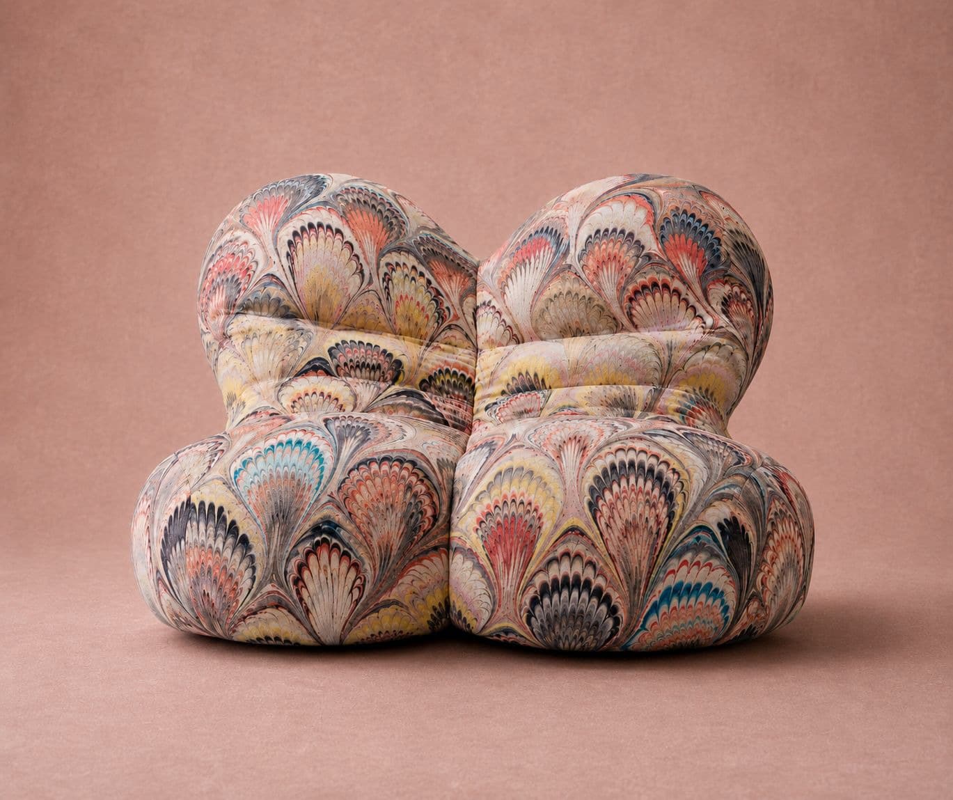 A deeply tufted, modular lounge seating unit upholstered in a vibrant, multi-colored marbled fabric. The design consists of rounded, plush cushions forming a backrest and seat, without visible legs or a traditional frame, presented as two closely-joined pieces. — 3D model