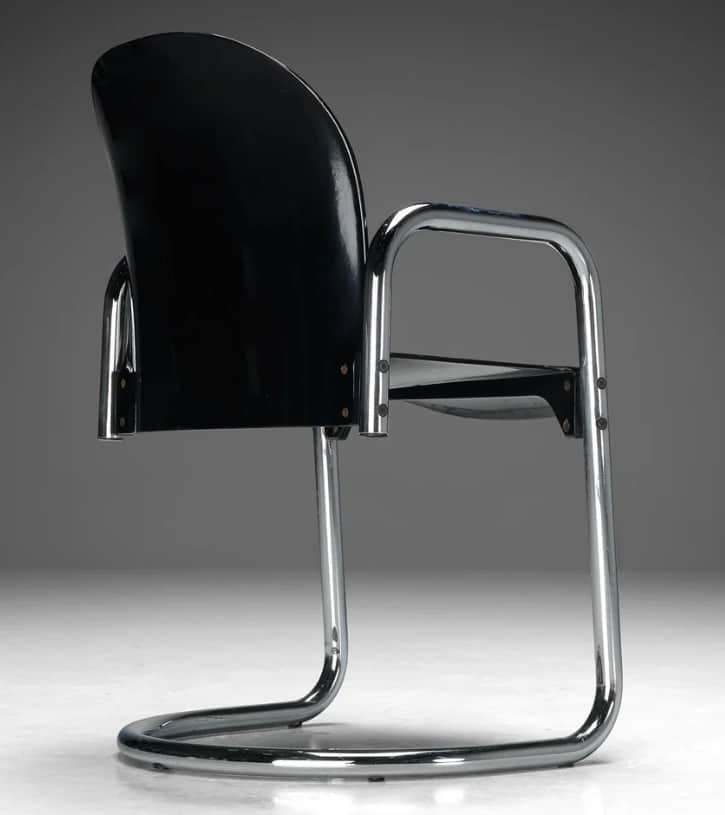 A cantilever armchair with a curved black seat and back, supported by a chrome-plated tubular steel… — 3D model