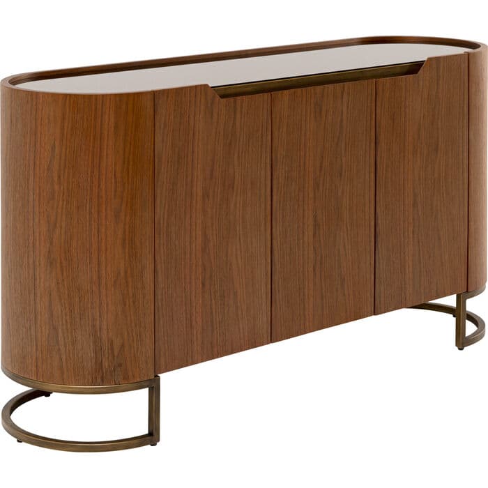 A contemporary sideboard featuring a curved, elongated oval form. It has a rich walnut wood finish, four solid cabinet doors, and a recessed brass trim along the top edge. The top surface is covered with a dark glass panel. The unit is supported by two semi-circular brass-finished metal bases at each end. — 3D model