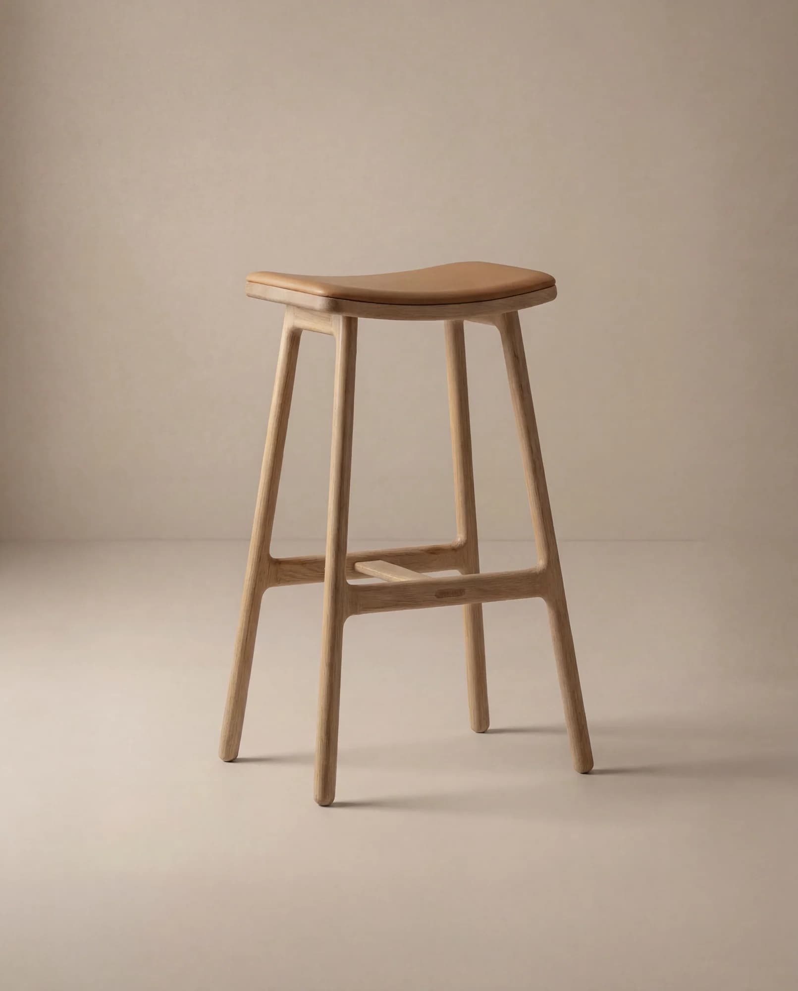 A modern bar stool featuring a light-toned wooden frame and a tan leather upholstered saddle-shaped seat. The four splayed legs are connected by integrated stretchers that double as footrests, showcasing a minimalist design. — 3D model