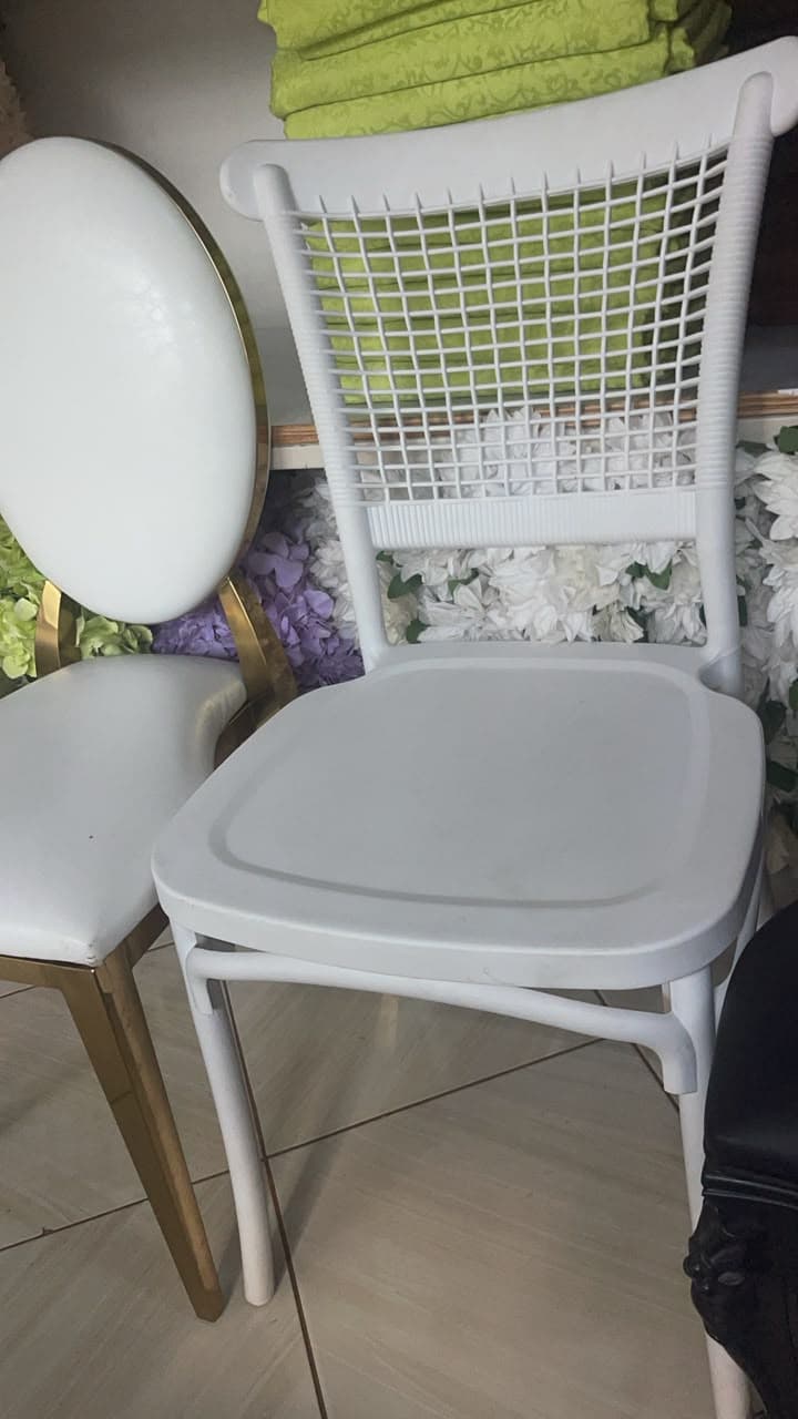A white, single-piece molded plastic chair featuring a distinct open-weave pattern on its backrest, mimicking traditional wicker or rattan. The chair has a solid seat and subtly curved legs, suggesting a contemporary and lightweight design suitable for various settings. — 3D model