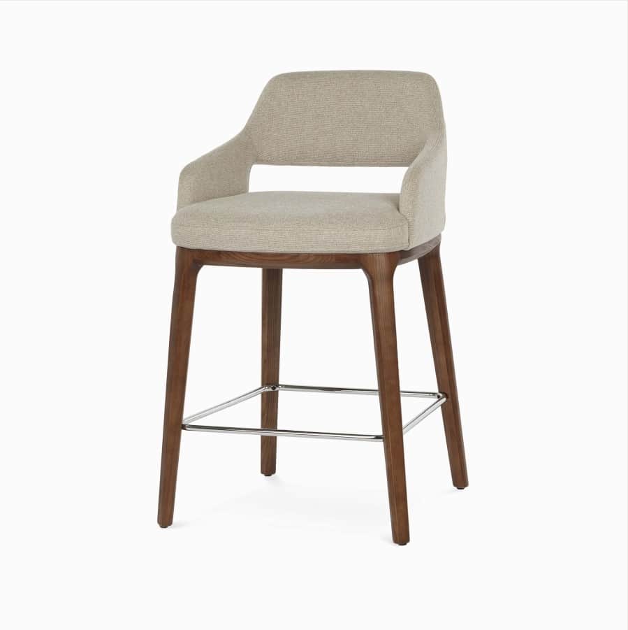 A contemporary bar stool with upholstered seating and backrest, supported by a wooden frame and legs… — 3D model