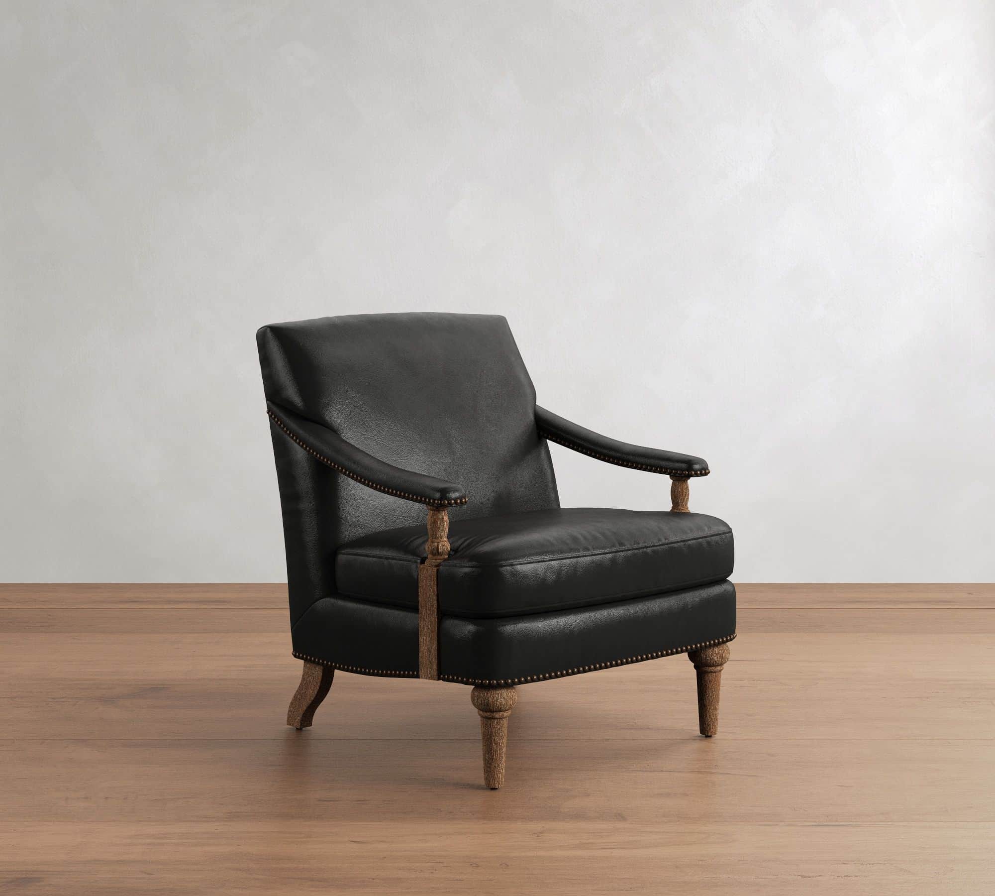 A traditional style armchair upholstered in black leather, featuring prominent brass nailhead trim a… — 3D model