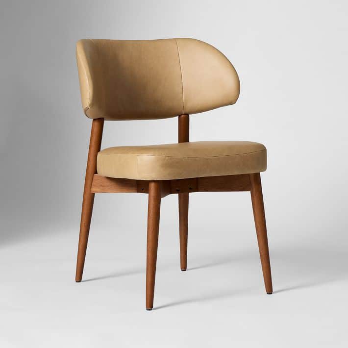 A tan upholstered accent chair with a curved backrest and a cushioned seat. The chair features a woo… — 3D model