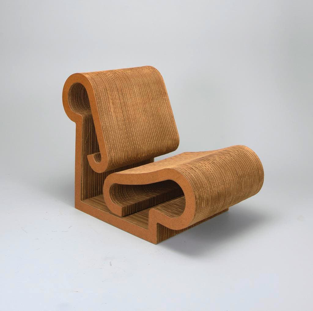 A sculptural lounge chair crafted from layered corrugated cardboard, featuring sinuous curves that form the backrest and seat. The natural brown color of the cardboard highlights its unique construction. — 3D model