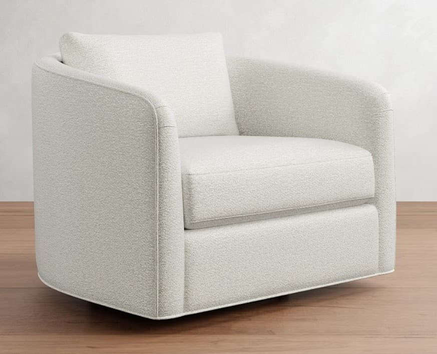 A contemporary armchair with a rounded silhouette and a swivel base. It features upholstered arms and a plush seat cushion, complemented by a loose back pillow. The textured fabric and clean lines suggest a modern aesthetic. — 3D model