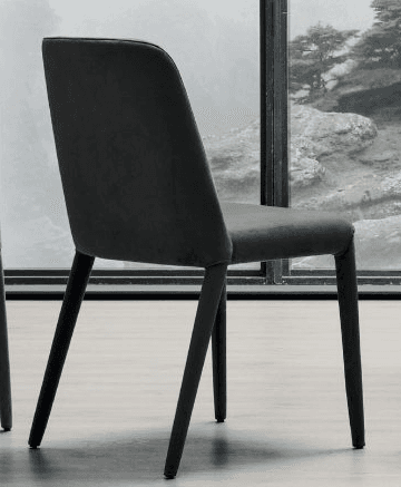 A modern upholstered chair with a curved backrest and four tapered legs. The chair has a minimalist design and appears to be upholstered in a dark, textured fabric. — 3D model