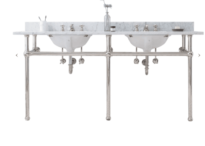 A double basin vanity with a marble top and backsplash, supported by a polished metal frame. Each basin has three faucets, and exposed plumbing is visible beneath. The vanity includes a countertop, two integrated sinks, a backsplash, and a metal stand with legs and horizontal supports. — 3D model