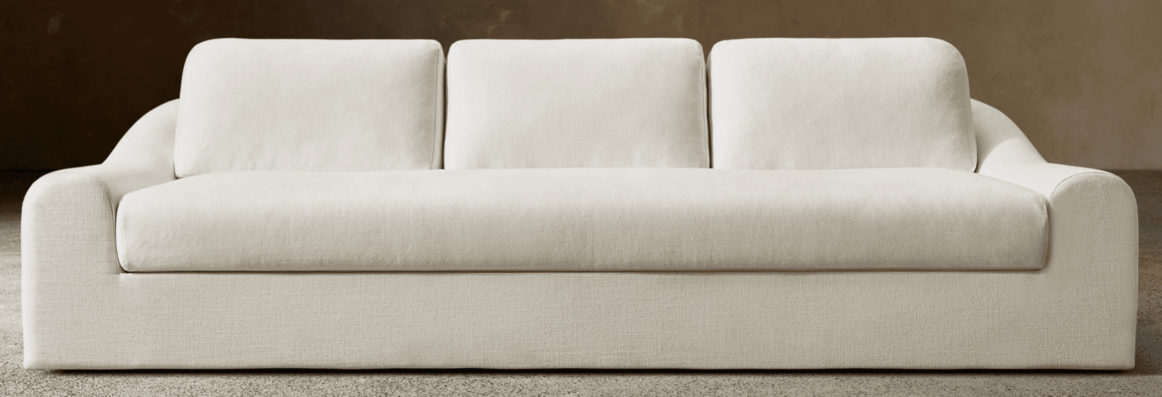 A modern three-seater sofa upholstered in a light-colored fabric. It features clean lines, track arms, and separate back and seat cushions. The base is fully upholstered, concealing any legs, giving it a low-profile, contemporary appearance. — 3D model