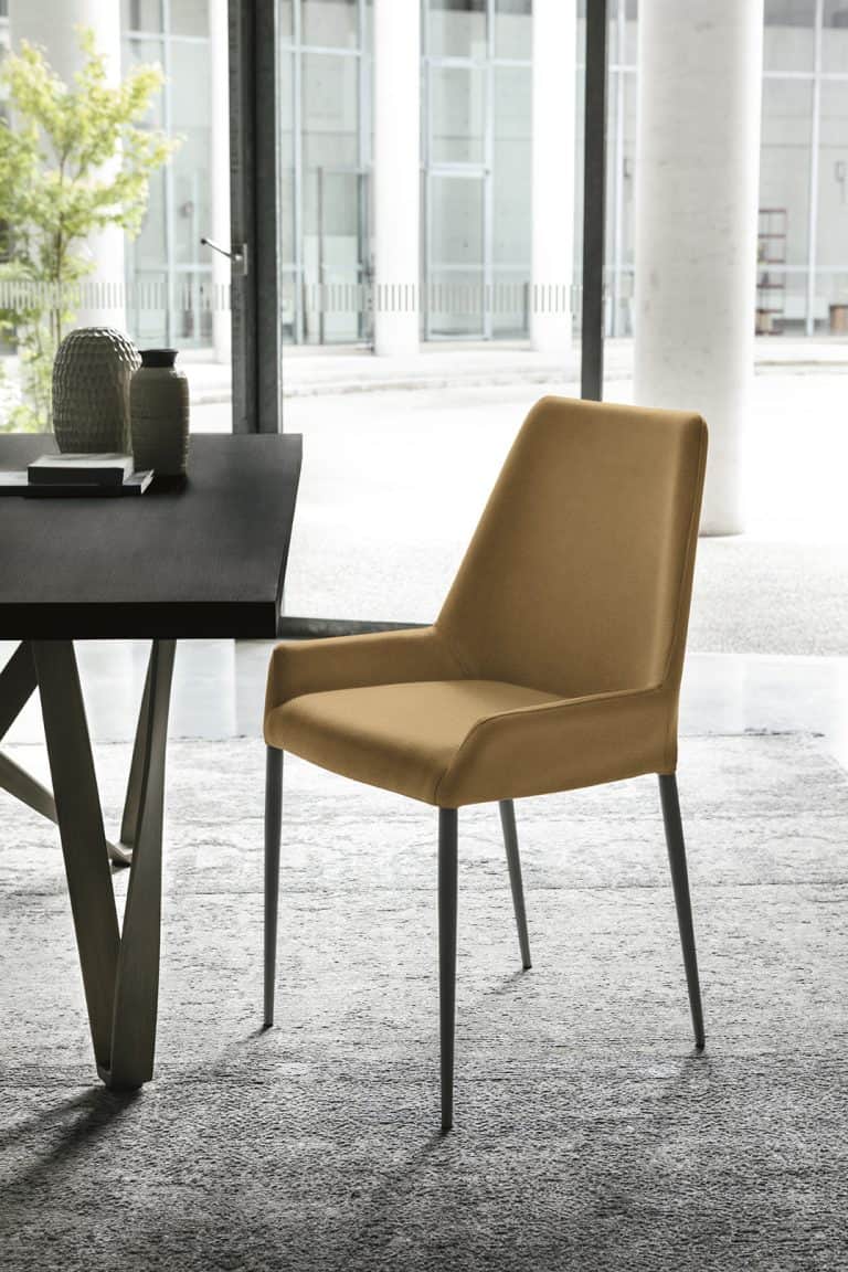 A contemporary dining chair featuring full mustard-yellow fabric upholstery and slender, tapered bla… — 3D model