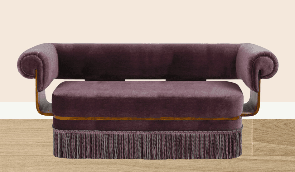 A plush, upholstered sofa with a deep purple velvet fabric. It features rolled arms with a distinct, curved wooden frame supporting them. The seat cushion is rounded and deep, and the base of the sofa is adorned with a decorative fringe. — 3D model