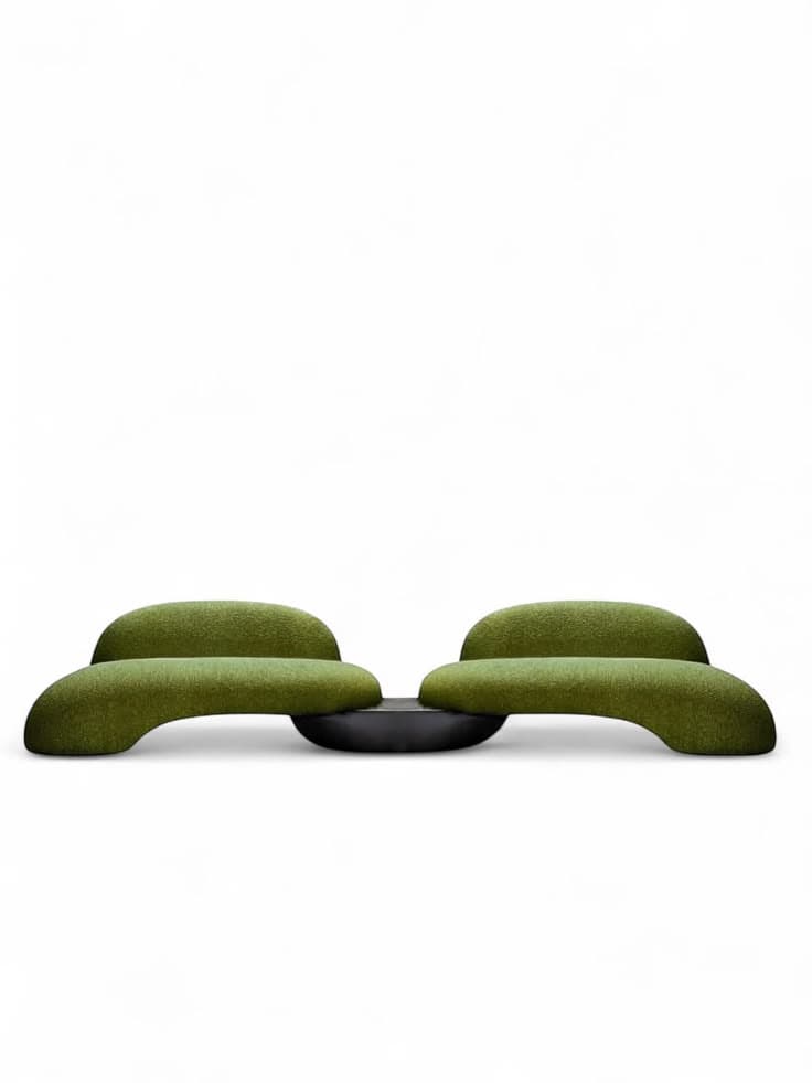 A modern organic modular bench featuring two curvilinear seating elements upholstered in green boucle fabric, connected by a central black platform. — 3D model