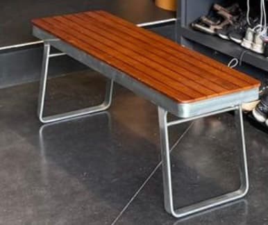 A modern bench featuring a rectangular seating surface composed of parallel wooden slats, supported by a minimalist, U-shaped metal frame. The design is sleek and contemporary, with clean lines and a combination of natural wood tones and a silver-grey metal finish. — 3D model