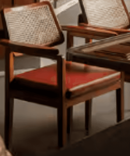 A contemporary armchair featuring a solid dark wood frame, a caned backrest, and a red upholstered s… — 3D model