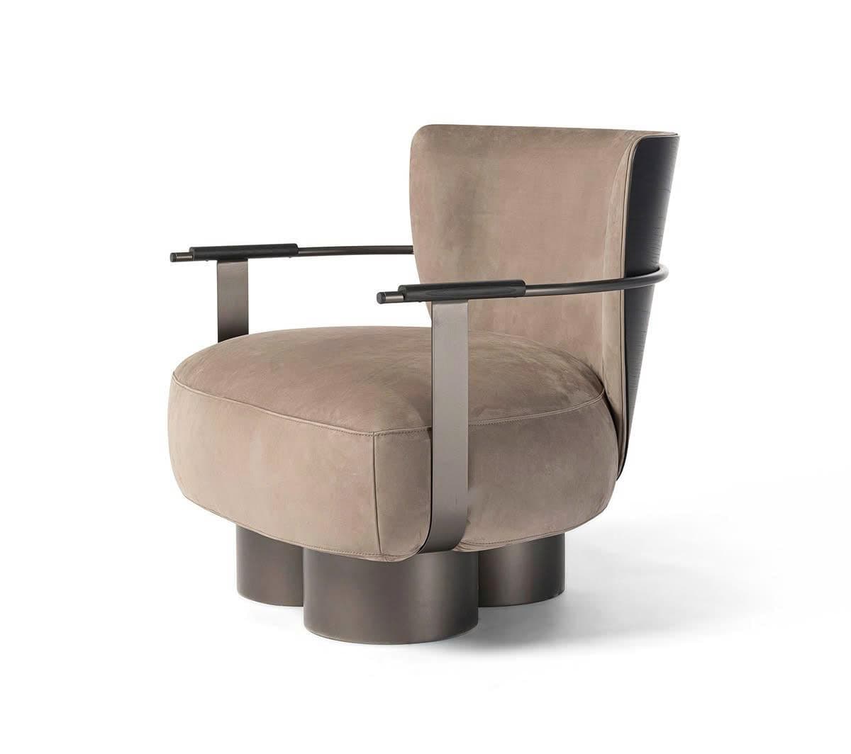 A contemporary upholstered armchair featuring a distinctive architectural metal frame and cylindrical pedestal legs. The upholstery is a soft, taupe-colored fabric, likely suede or a similar textile. The dark grey metal frame forms the armrests, curving elegantly from the base and supporting horizontal armrest bars. The chair's back also incorporates a darker, possibly wood or metal, element that integrates with the armrest structure. Three solid cylindrical legs provide stable support. — 3D model