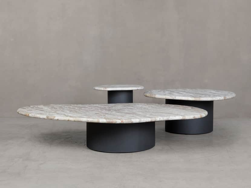 An oval-shaped coffee table featuring a white and grey veined marble top supported by a dark grey, c… — 3D model