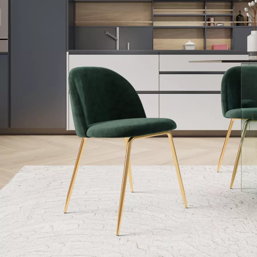 An armless dining chair featuring a curved back and seat upholstered in emerald green velvet, supported by four slender, gold-finished metal legs. — 3D model