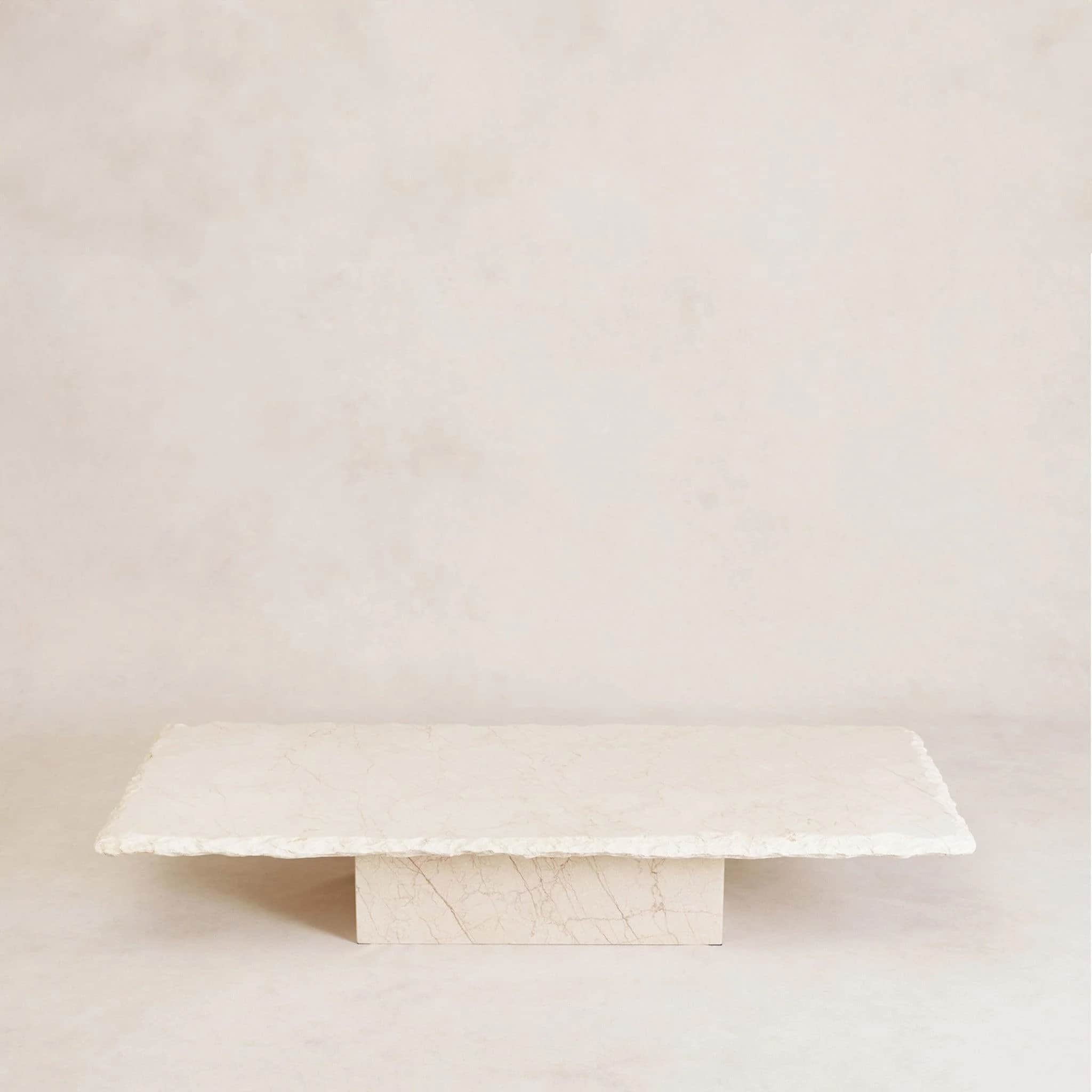 A rectangular coffee table with a thick, irregularly shaped stone top and a solid stone block base.… — 3D model