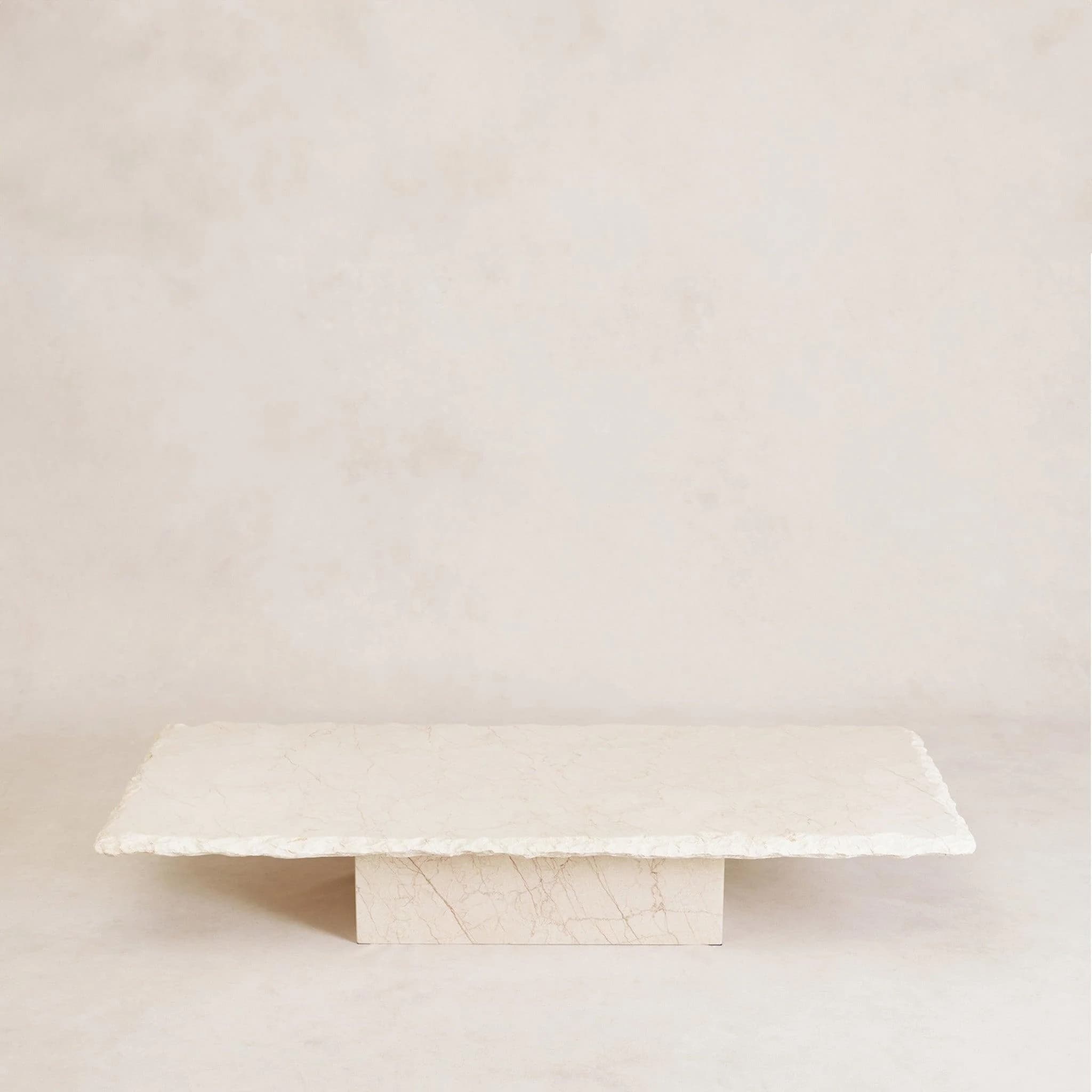 A rectangular coffee table with a thick, irregularly shaped stone top and a solid stone block base. The stone exhibits natural veining patterns. — 3D model