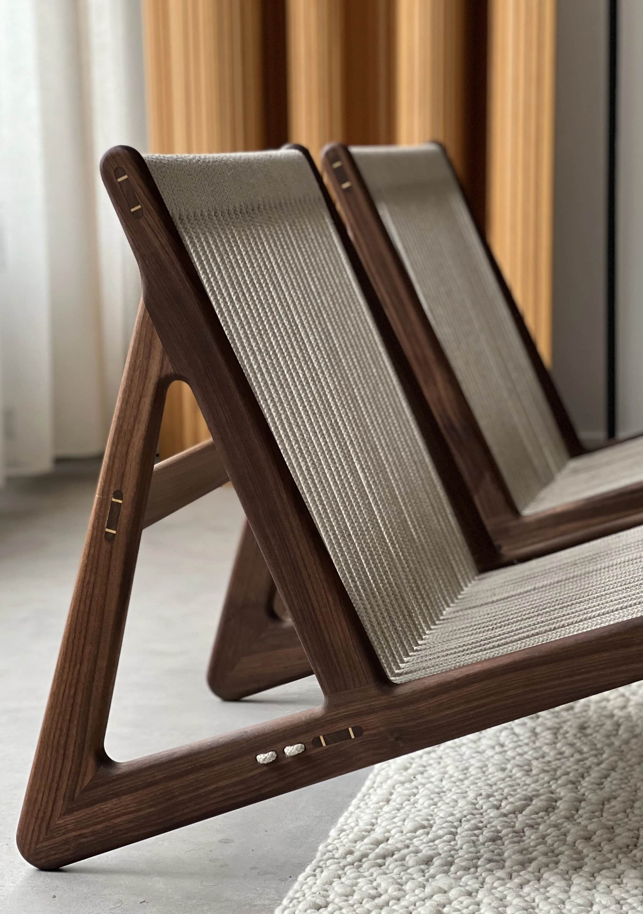 A contemporary low-profile lounge chair featuring a dark wooden frame and a woven rope seat and back… — 3D model